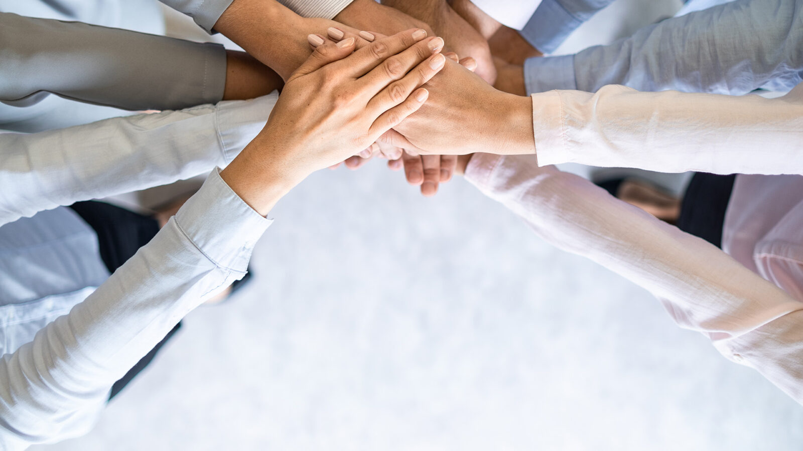 group of business people with their hands stacked on top of each other